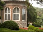 Rounded Corner of House with Green Lawn and Shrubs